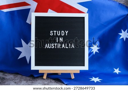 Message STUDY IN AUSTRALIA on background of Australian flag made from silk. Australia national flag with concept of tourism and traveling students opportunities scholarship programs 