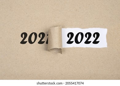 
				Message Year 2021 replaced by 2022 torn craft paper texture background.
				Good bye 2021 hello to 2022 happy New Year coming concept.