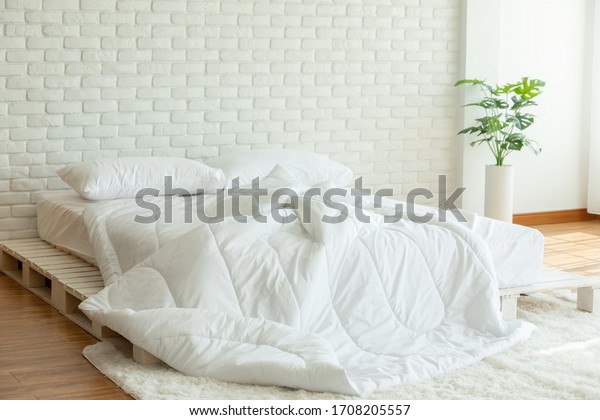 Messed bed with white pillow and duvet\
blanket with natural light in bedroom in the morning,Messy bed\
after wake up,Messy bed and Cozy Bedroom\
Concept