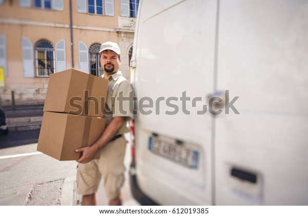 Messenger\
Delivering Parcel, Standing Next To His\
Van