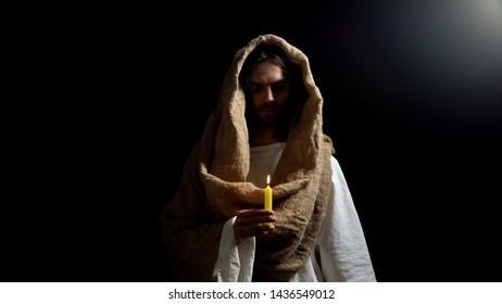 Messiah holding candle, praying for people sins expiation, belief and kindness - Shutterstock ID 1436549012