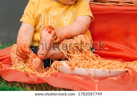 Messy baby and a bowl of spaghetti