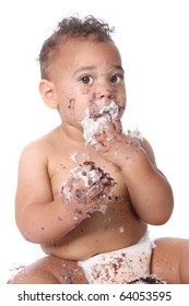 Messy baby boy eating cake on his 1st birthday
