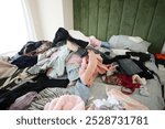 A Messy Bed with Various Colorful Clothes and Soft Pillows Is a Cozy and Casual Space