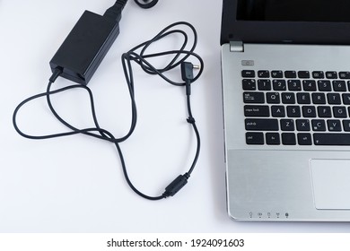 Messy Charging Cable Adapter Of Laptop Computer On White Background