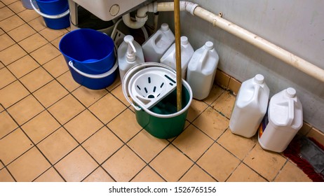 Messy Cleaners Cupboard With Mop And Buckets And Containers Of Cleaning Fluids