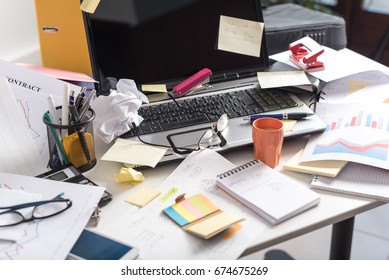 Messy and cluttered office desk - Shutterstock ID 674675269