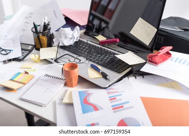Messy and cluttered office desk - Shutterstock ID 697159354