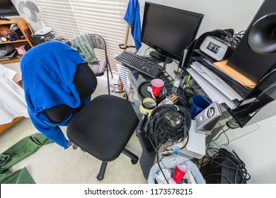 Messy, Cluttered Teenage Boys Bedroom Desk And Work Area.  