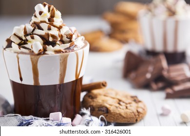 A messy cup with hot chocolate, whipped cream, marshmallows and chocolate chip cookies. - Powered by Shutterstock