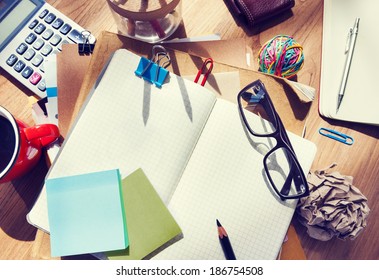 Messy Designer's Table with Blank Note and Tools