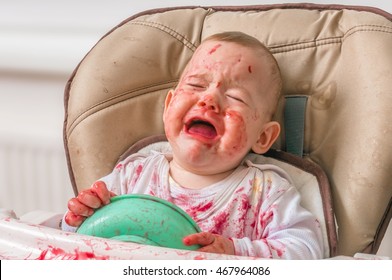 Messy And Dirty Baby Is Eating Snack And Crying.