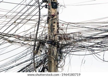 messy electricity wires on the pole, The chaos of cables and wires on an electric pole in Thailand