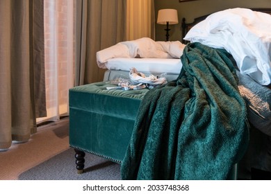 A Messy Hotel Bed And Bathrobe.