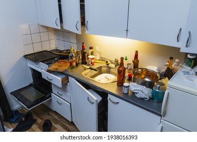 Messy Kitchen After Party. Beer Bottles, Plates In A Sink, Wine Bottle