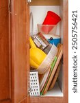 Messy kitchen cabinet or cupboard with various accessories and utensils