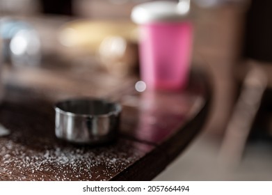 Messy Kitchen Table Top With Measuring Cup And Granules Of Sugar 