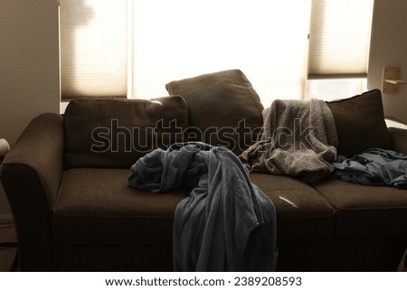 messy lived in couch with blankets laying around 