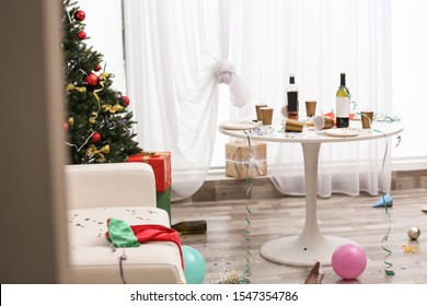 Messy Living Room Interior With Christmas Tree. Chaos After Party