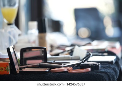 Messy Makeup On Black Table, With Mimosa On Table And Blurry Background (bokeh). 