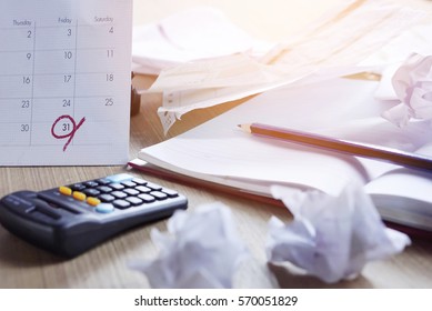  Messy Office Desk During Tax Season With Deadline On A Calendar, Unfinished Document, And Late Payment 