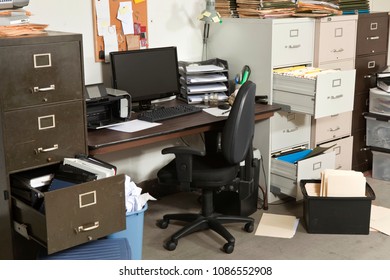 Messy Office With Piles Of Files And Disorganized Clutter.