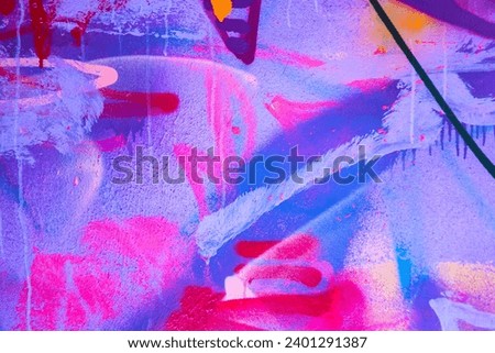 Messy paint strokes and smudges on an old painted wall. Pink, purple, white color drips, flows, streaks of paint and paint sprays