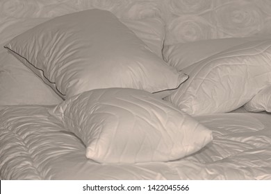 Messy soft pillows pile inside modern unmade bed in the morning