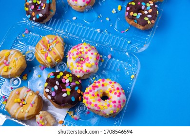 Messy Sprinkled Mini Donuts In A Clam Shell Package On Blue