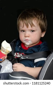 Messy Toddler With An Ice Cream Cone Sitting In His Car Seat