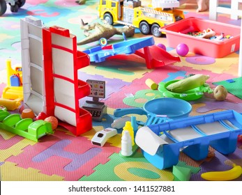 Messy Toys On Soft Alphabet Mats In Kids Room.