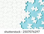 messy white jigsaw puzzles on blue background
