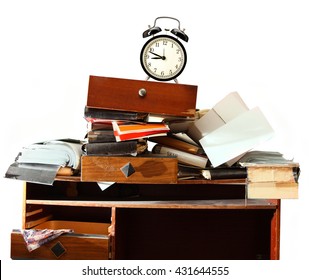 Messy workplace with stack of old paper and alarm clock