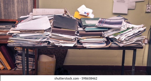 Messy workplace with stack of old papers