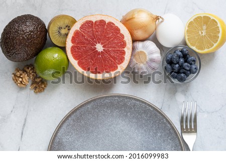 Metabolism-boosting foods: eggs, grapefruit, avocado, blueberries, onions, garlic, nuts, kiwi.  Top view