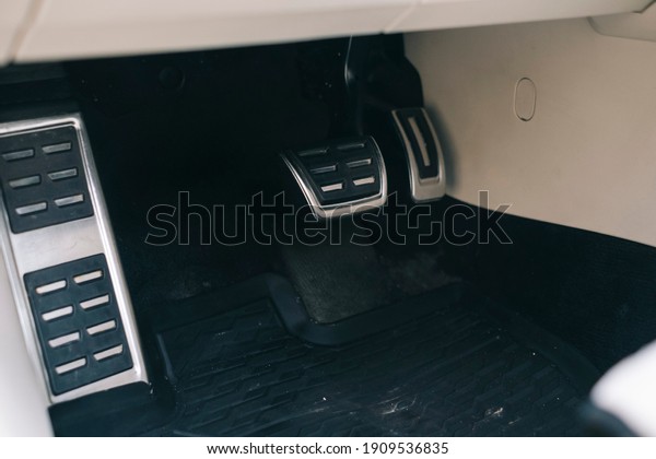 Metal\
accelerator and breaking pedal in a\
car.