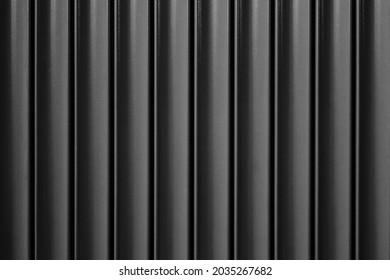 Metal automatic sliding gates close up. Vertical construction sections, house exterior, fencing, monochrome black and white background.