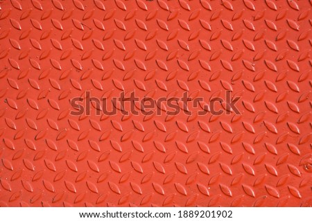 Metal background with chicken paw pattern painted in bright orange, for background image or add text. Embossed metal plates are used for areas prone to slipping,such as passenger ships,buses,overpasse
