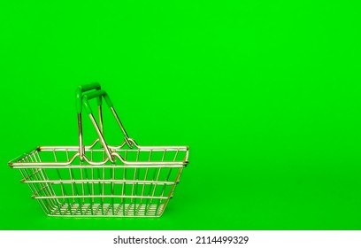 Metal basket for groceries from the supermarket on a green background. The concept of online trading, shopping, sale, delivery of goods with place for text and copy space. good quality photo