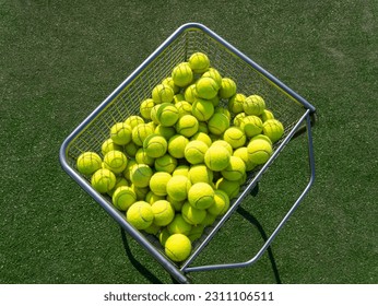 Metal basket with a large number of yellow tennis balls - Powered by Shutterstock