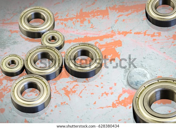 Metal Bearings on a\
Grunge background with reflection. Composition with bearings.\
Mechanisms, transport.