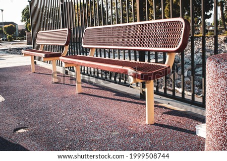 Metal bench at urban public park in morning