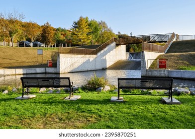 Metal benches facing a creek - Shutterstock ID 2395870251