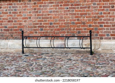 The Metal Bicycle Rack (bike Rack) In The Wall Brick Background