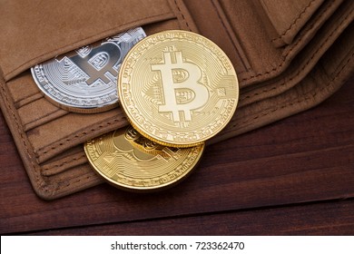 Metal bitcoins in brown leather wallet. Bitcoin - modern virtual