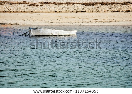 A metal boat floats by it self in a Cape Cod harbor