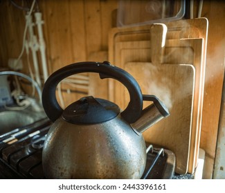 a metal boiling kettle with a whistler and steam coming out against the chopping boards - Powered by Shutterstock