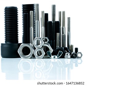 Metal Bolts And Nuts On White Background. Fasteners Equipment. Hardware Tools. Stud Bolt, Hex Nuts, And Hex Head Bolts In Workshop. Threaded Fastener Use In Automotive Engineering. Hexagonal Bolt.