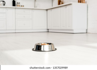 Metal Bowl With Dog Food On White Floor In Kitchen 