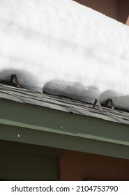 Metal Brackets On Home Exterior Roof To Prevent Snow From Falling From Roof In Winter Or Spring Layers Of Heavy Snow On Top Of Shingled Roof Of Home Vertical Format Empty Space Or Room For Type 